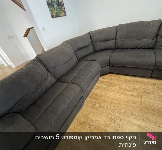 ספת בד פינתית גדולה בצבע אפור כהה לאחר ניקוי בסלון ביתי
